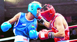 Akhil Kumar (in red) lands a blow to Mauritian pugilist Louis Julie during the quarterfinal bout of the 58-kg category boxing event at Talkatora Indoor Stadium on Sunday.