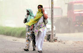 Women cover their faces during a dust storm in Chandigarh on Monday.