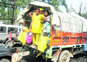 IN THE NAME OF GOD: Pilgrims board a truck near a temple in Kangra