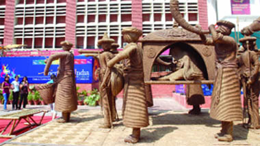 People look at jute sculptures depicting a marriage procession at Connaught Place in New Delhi on Tuesday. A total of 70 artisans have prepared the sculptures. 