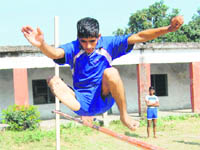 An athlete participates in the high-jump event at the District Athletics Competition at Nehrugram in Dehradun on Tuesday.