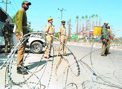 Security personnel stand guard in Srinagar on Tuesday where the curfew was imposed.