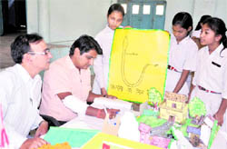 Judges check models made by schoolchildren during a science exhibtion in Bahadrabad, Haridwar, on Wednesday
