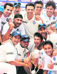 Members of the Indian cricket team pose with the series winning Border-Gavaskar trophy during the presentation ceremony after the second Test between India and Australia at M Chinnaswamy Stadium in Bangalore on Wednesday. India won the match by 7 wickets to complete a maiden series whitewash (2-0) of the Australians.