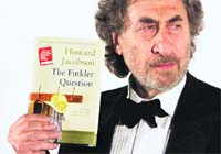 British author Howard Jacobson, the winner of the Booker Prize, poses with his book 'The Finkler Question' in London