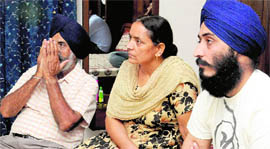 Indian hockey skipper Rajpals father Harpal Singh (left), mother and brother in a pensive mood while watching the India-Australia hockey final at their residence in Mohali on Thursday.
