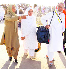 A policewoman assists a couple going for Haj at Srinagar airport. 