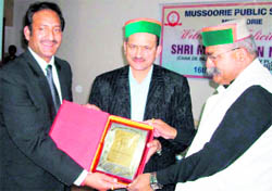 Mussoorie Public School Principal Mukesh Lal, along with MLA Jot Singh Gunsola, felicitates Mir Ranjan Negi with a memento