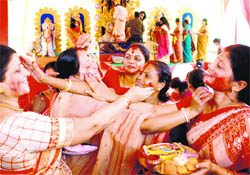 Women apply colour on each other during Durga Puja celebrations in Sector 5, Panchkula