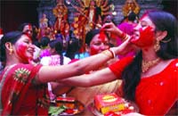 Women play with vermillion as the 10-day festival ends at Aaram Bagh
