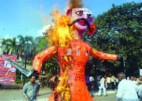 BJP activists burn the effigy of Sheila Dikshit at Town Hall in New Delhi