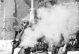 An Israeli border policeman fires tear gas towards Palestinian protesters during clashes in the East Jerusalem neighbourhood of Silwan
