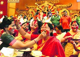 Women play with colours during the immersion procession of Goddess Durga to mark the end of the nine-day Durga Puja festivities in Gurgaon