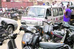 Vehicles parked haphazardly on a road outside AC Market, Bhadaur House