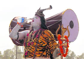 A man dressed as Lord Shiva drinks water from a bottle in Dehradun on Monday.