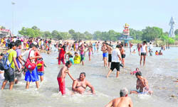 Pilgrims take a bath in knee-deep water in Haridwar on Monday. 