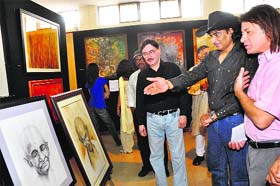 Bobby Cash, eminent singer ( in a hat), admires a painting of Aloke Lal, DGP, Prosecution (left), at his exhibition in Dehradun