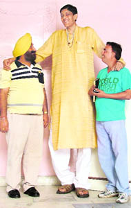 8-foot-tall Dharmendra Pratap Singh strikes a pose with his relatives in Ludhiana on Monday.