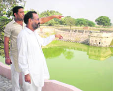 Jatinder Sharma and Pandit Hem Raj point towards the encroachments on the temple land in Kalyan Malka village in Bathinda district.