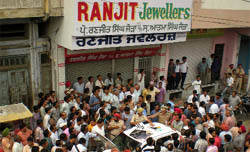 Police and people assemble around the car belonging to the alleged miscreants at Sirki Bazar in Bathinda on Wednesday