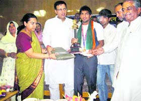 Commonwealth Games boxing gold medallist Manoj Kumar being honoured by state PWD Minister Randeep Singh Surjewala at a function in Kaithal