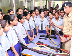 Police officials show weapons to schoolchildren at the Sector 19 police station in Chandigarh on Wednesday.