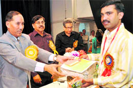Chief Secretray Subhash Kumar gives away a prize to an employee at a BSNL Day function in Dehradun on Wednesday