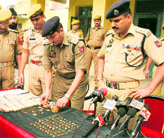 Stolen gold items and cash being displayed at Pucca Danga police station in Jammu on Wednesday