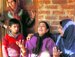 Fatima, whose husband, Mohammad Ashraf Mir, was killed in police firing, being consoled by her relatives