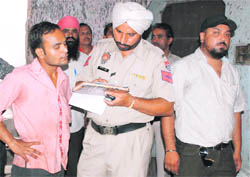Head constable Darshan Singh records the statement of a neighbour of Shiv Pradhan, who was murdered, in Ludhiana