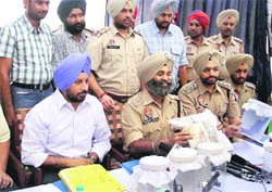 Police officials with the recovered pistols and cash in Mandi Gobindgarh
