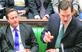 UK Finance Minister George Osborne announces the governments spending plans in Parliament as Prime Minister David Cameron looks on.