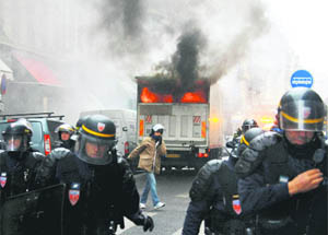 Riot police officers move back from a burning truck during clashes with youths in Lyon, France, on Wednesday.