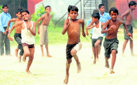 Children take part in a relay race during a block-level annual sports and cultural meet at Karnals Karan Stadium