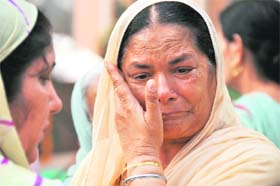 Surjit Kaur, widow of a policeman, wipes her tears on the Police Commemoration Day in Ludhiana