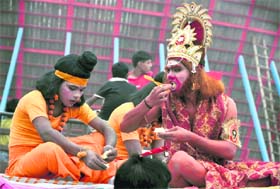 Artistes enacting as Lord Rama and Hanuman take a break to have a snack during the Bhagwan Valmiki Parkashotsav shobha yatra in Ludhiana