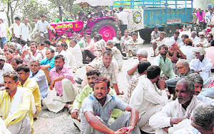 Residents of Siwan village hold a protest, after the death of a youth, near Khanpur on Friday.