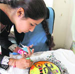A girl paints a T-shirt during an inter-college talent hunt organised at SIFT in Ludhiana