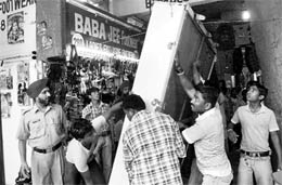 MC enforcement staff remove material lying in the corridor of Shastri Market, Sector 22, during an anti-encroachment drive in Chandigarh on Saturday