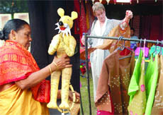 (Left) A 'Shera' doll displayed in a stall; (right) a visitor checks clothes at Dastkar-Nature Bazaar, Janpath, in New Delhi. 