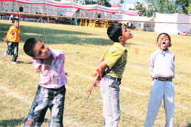 Students participate in a biscuit race at Marshall School In Dehradun on Sunday.