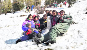 Tourists enjoy fresh snowball at Gulaba near Manali on the Rohtang road on Sunday.