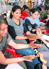 Girls get mehndi applied to their hands for the festival of Karva Chauth falling on Tuesday, at Dhobi Bazar in Bathinda on Sunday