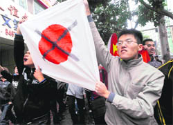 A Chinese protester holds a defaced Japanese national flag during their anti-Japan demonstration over a territorial dispute in Lanzhou on Sunday. 