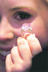 An employee of Sotheby's auction house holds a 24.78- carat fancy intense pink diamond mounted as a ring, that was last seen on the market some 60 years ago according to the house, ahead of an upcoming auction in central London, Monday. The rare emerald-cut pink diamond is estimated to fetch some $27-38 million when it is auctioned in Geveva, Switzerland on November 16 as part of the house's 'Magnificent Jewels Sale'.