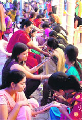 Women get henna applied to their hands on the eve of Karva Chauth in Chandigarh on Monday.