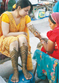 A woman gets henna applied on her hands on the eve of Karva Chauth in New Delhi on Monday.