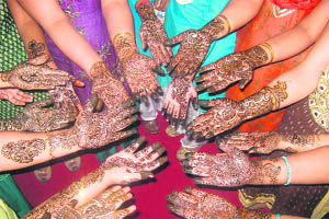 Students and teachers show their mehndi during a contest organised on the eve of Karva Chauth at the MM College of Education in Fatehabad on Monday.