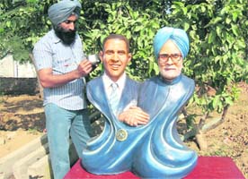 Manjit Singh gives the finishing touches to his sculpture of US President Barack Obama and Prime Minister Manmohan Singh in Moga