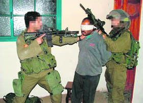 A handout picture obtained from the Israeli human rights organisation, Breaking the Silence, on Monday allegedly shows an Israeli soldier pointing his assault rifle at a blindfolded detainee in an undisclosed location. Breaking the Silence is a group of Israeli veteran combat soldiers who collect testimonies and photos of troops who have served in Palestinian territories. 